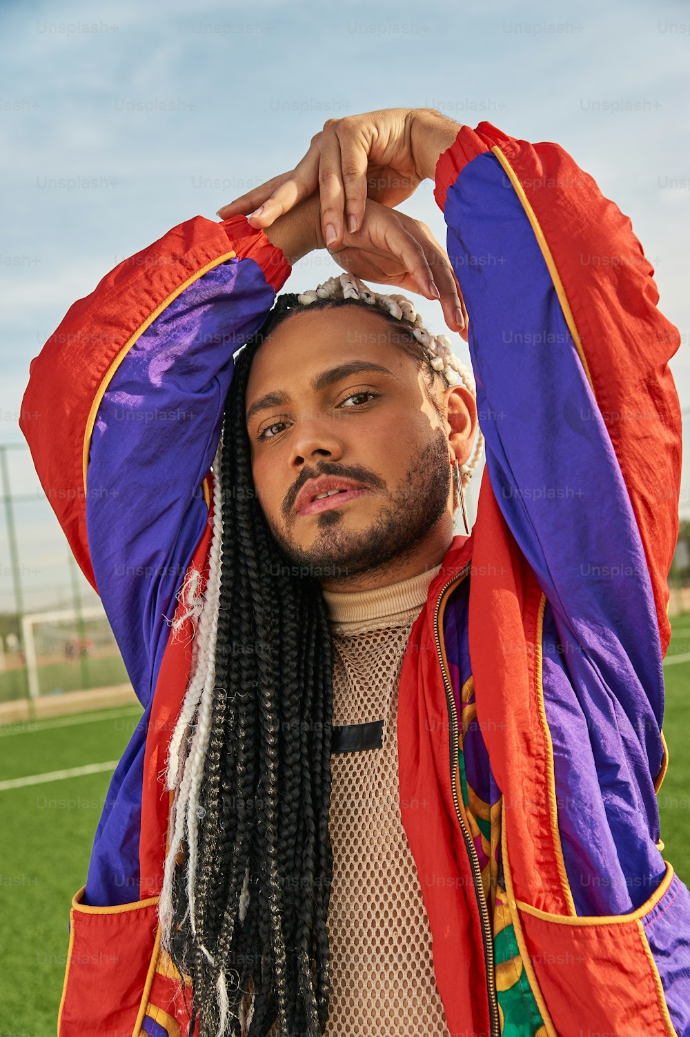 a man with dreadlocks and a jacket on