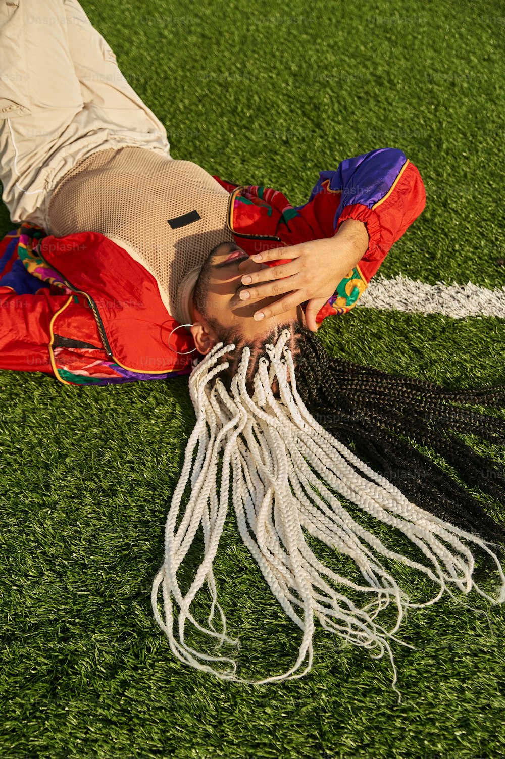 a person laying on the ground with their hands on their head