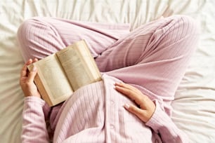 a woman laying in bed reading a book