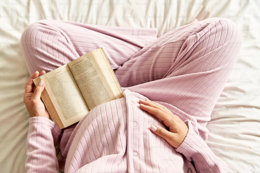 a woman laying in bed reading a book