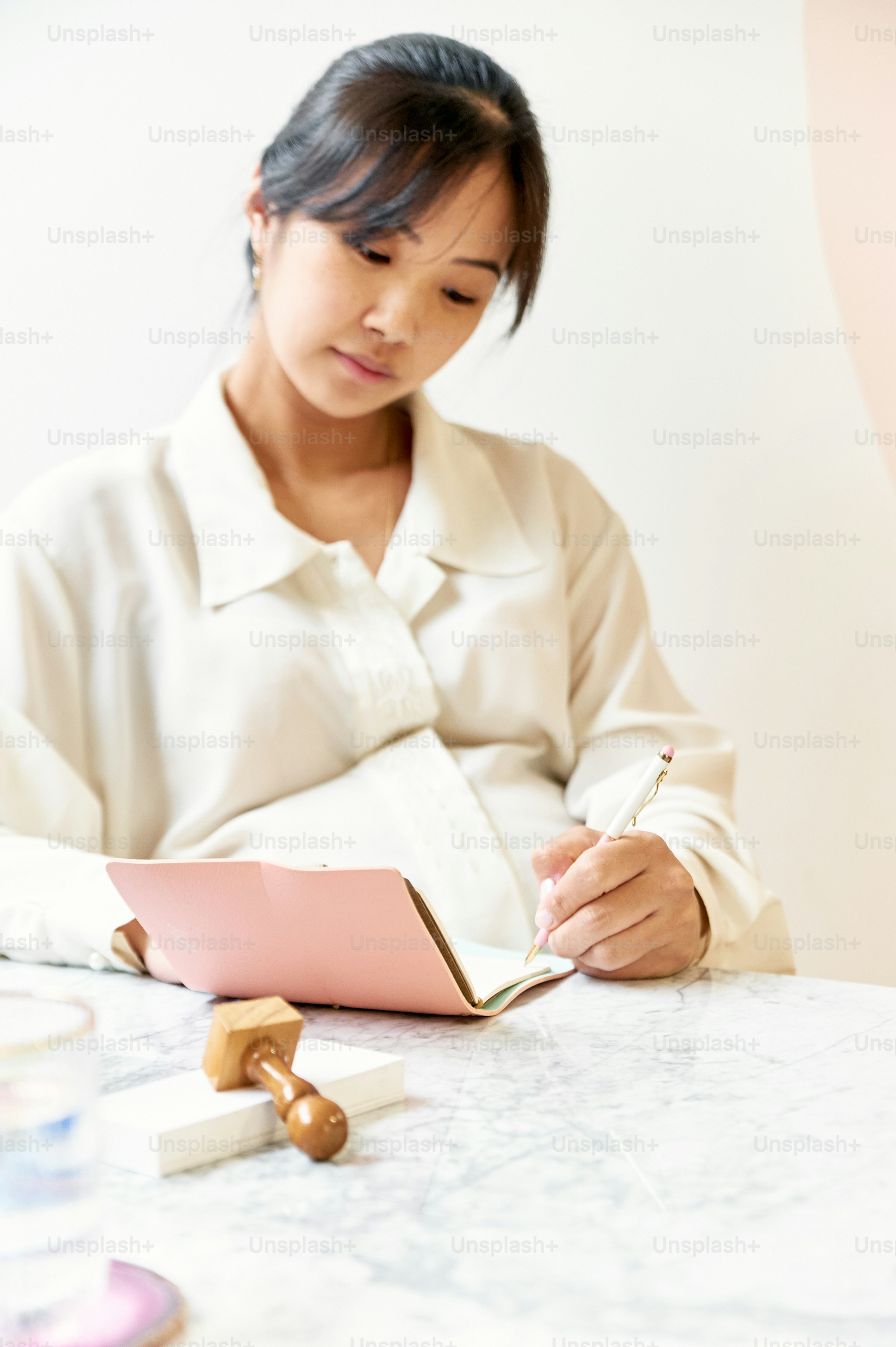 una donna seduta a un tavolo che scrive su un quaderno