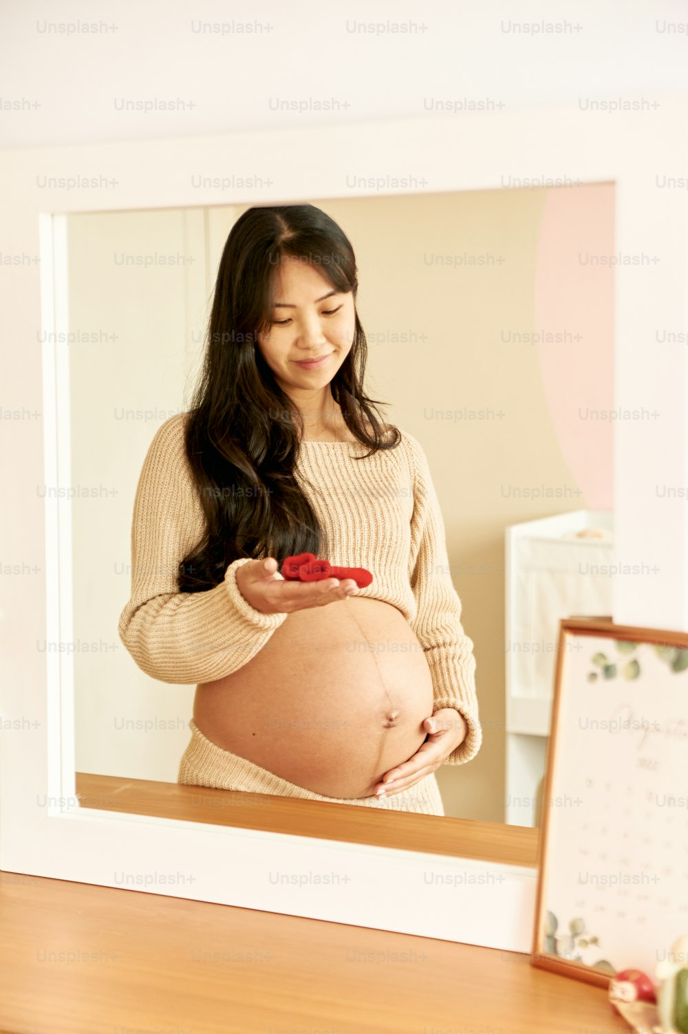 una mujer embarazada mirando su teléfono celular