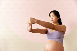 Eine schwangere Frau, die ihre Muskeln für ein Bild spielen lässt
