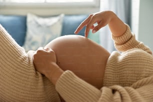 a pregnant woman laying on a couch with her hand on her belly