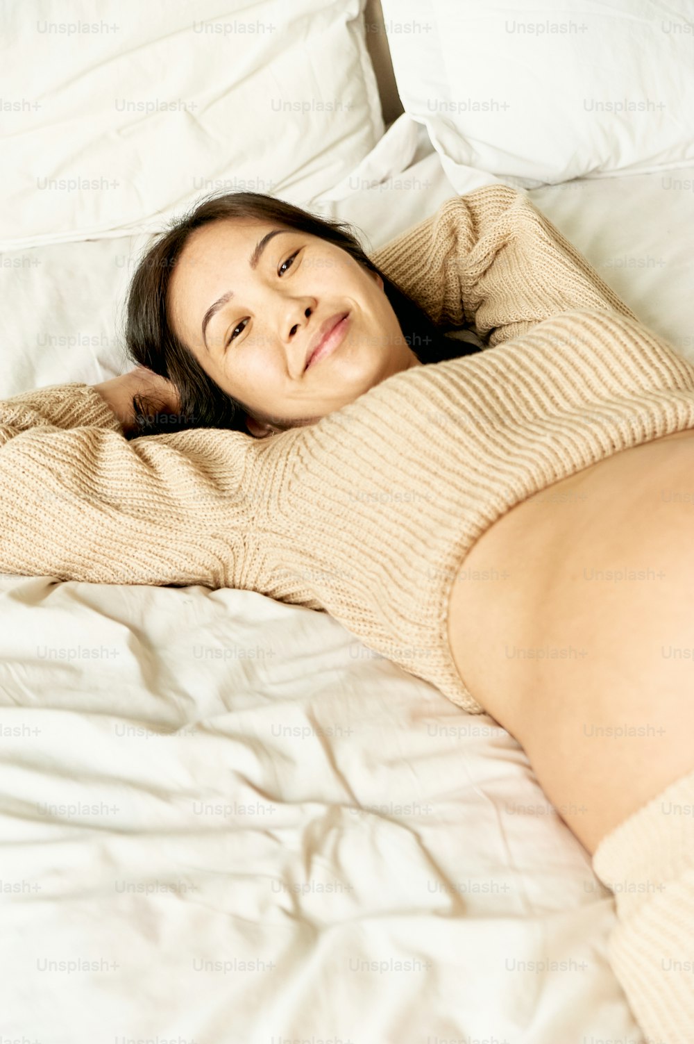 Une femme allongée sur un lit sous une couverture