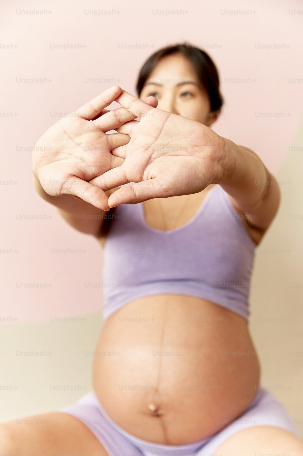 uma mulher grávida segurando as mãos no ar