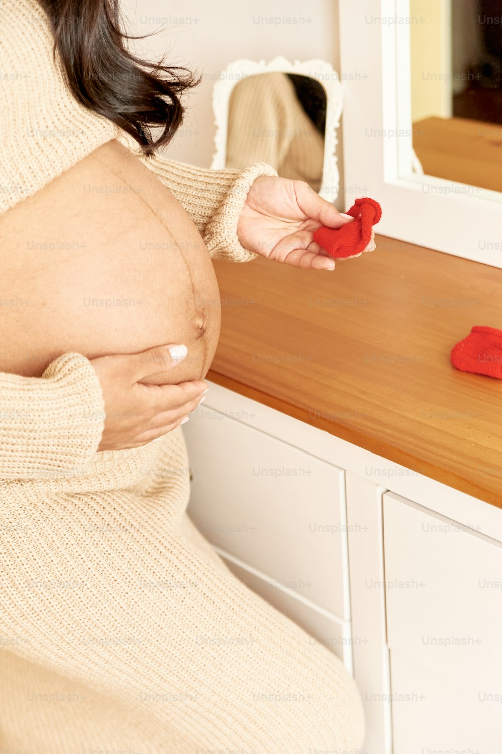 a pregnant woman holding a red object in her hand