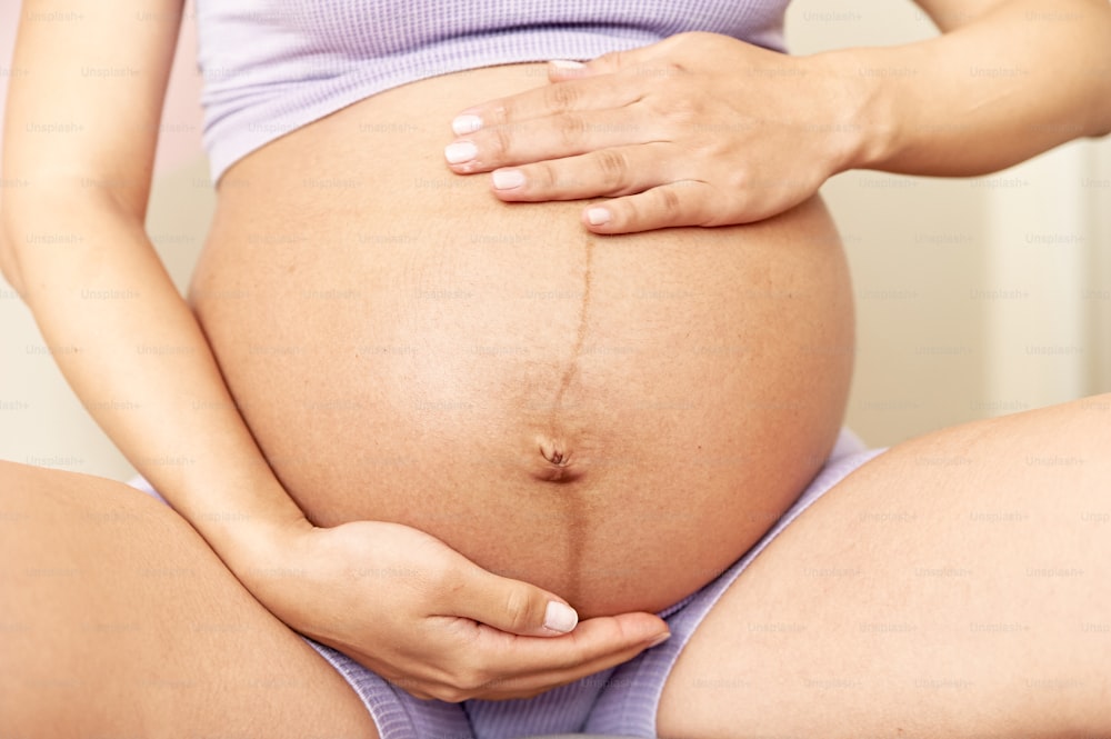 a pregnant woman holding her belly in her hands