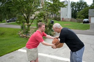 a man holding a basketball while standing next to another man