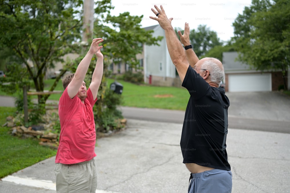 two men reaching up to catch a frisbee