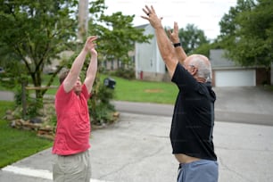 two men reaching up to catch a frisbee
