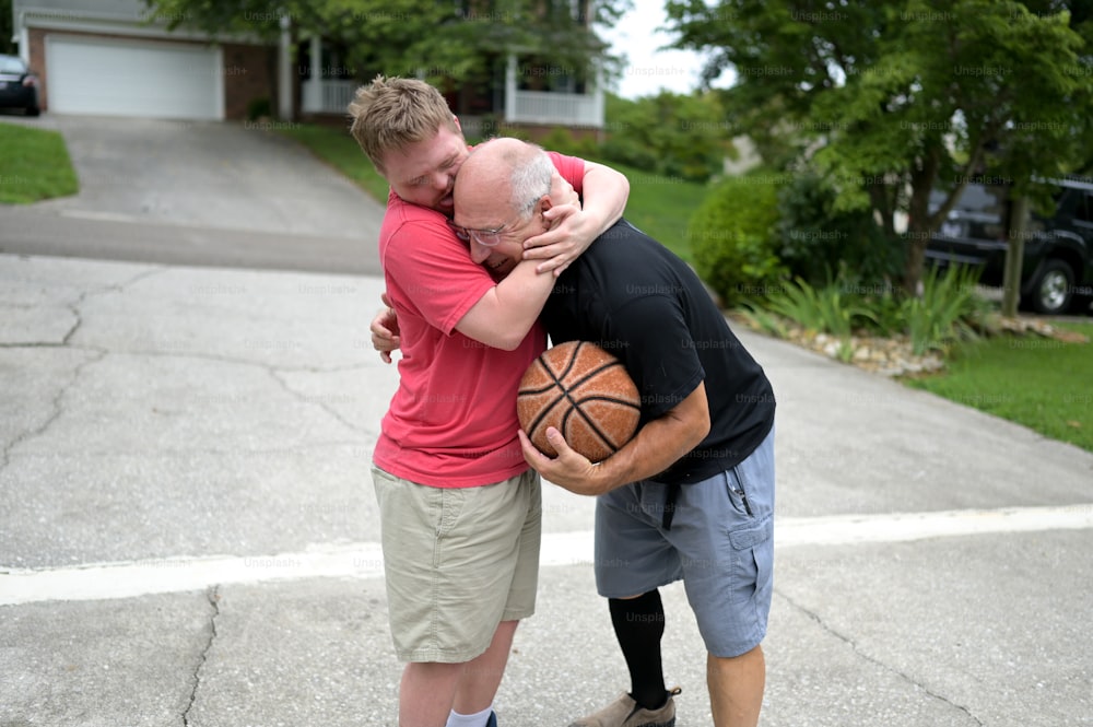 Un homme étreint un autre homme avec un ballon de basket