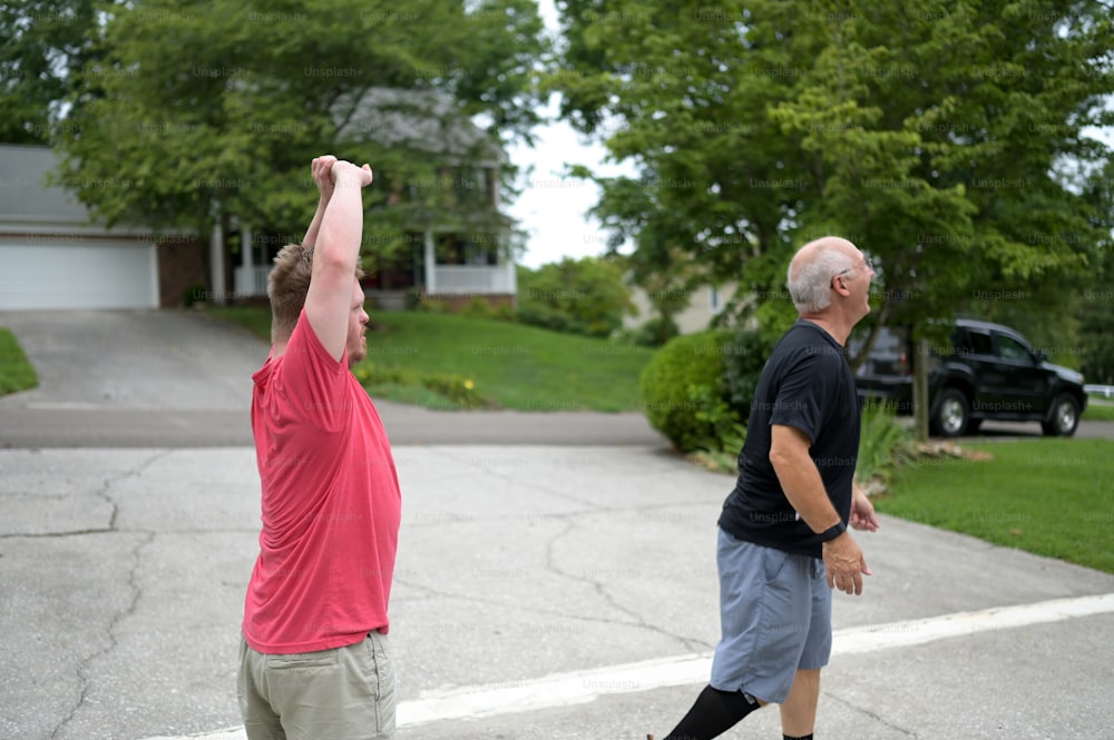 Dos hombres están jugando frisbee en un camino de entrada