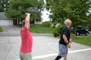 two men are playing frisbee in a driveway