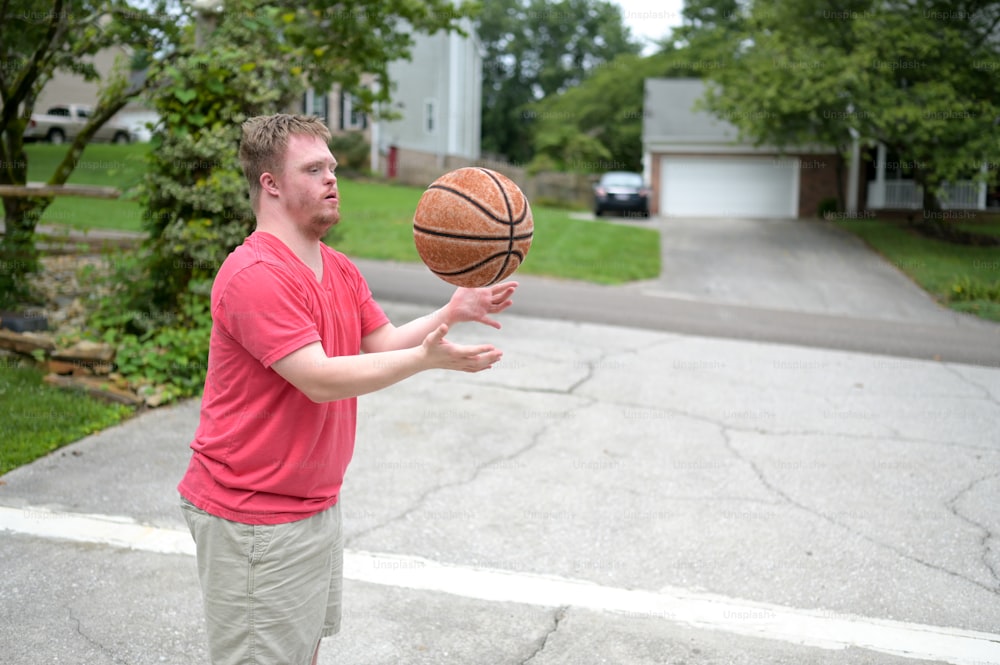 a man in a red shirt is holding a basketball