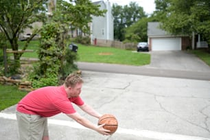 a man in a red shirt is holding a basketball