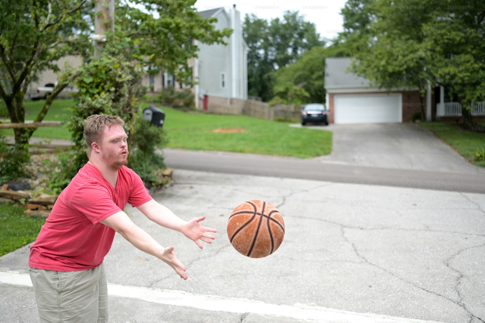 a man in a red shirt is throwing a basketball