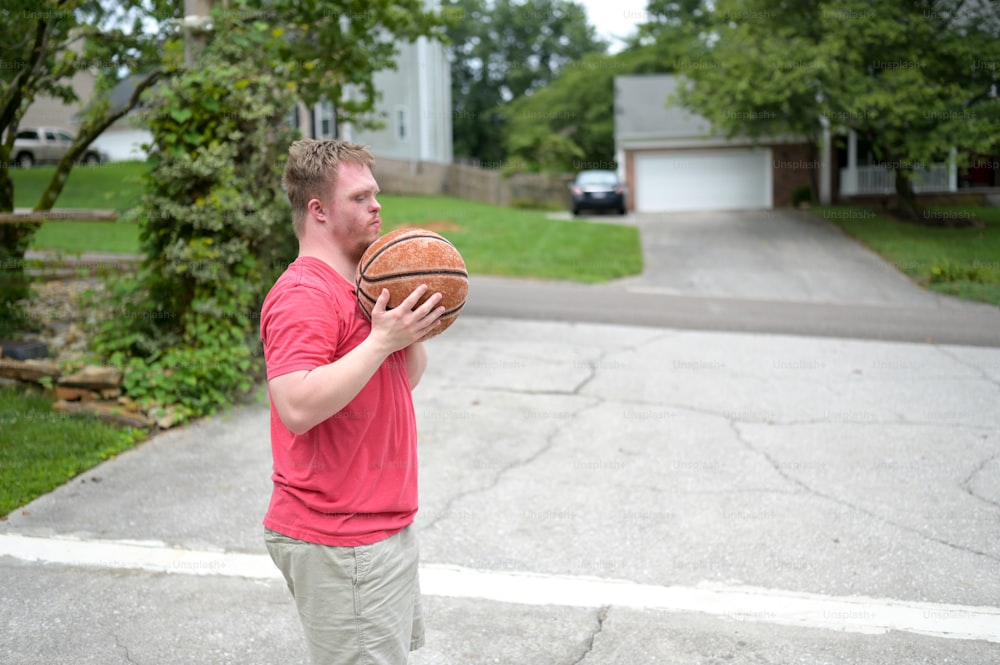 Un hombre con una camisa roja sosteniendo una pelota de baloncesto