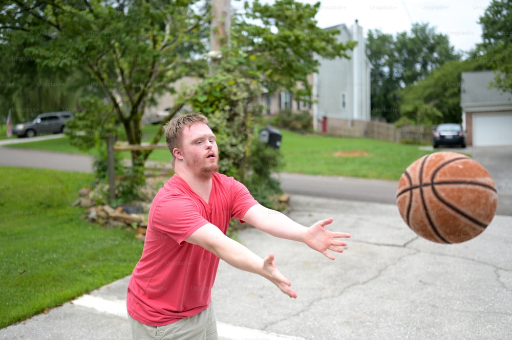 Un hombre con una camisa roja lanzando una pelota de baloncesto