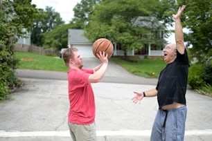 two men are playing with a basketball outside