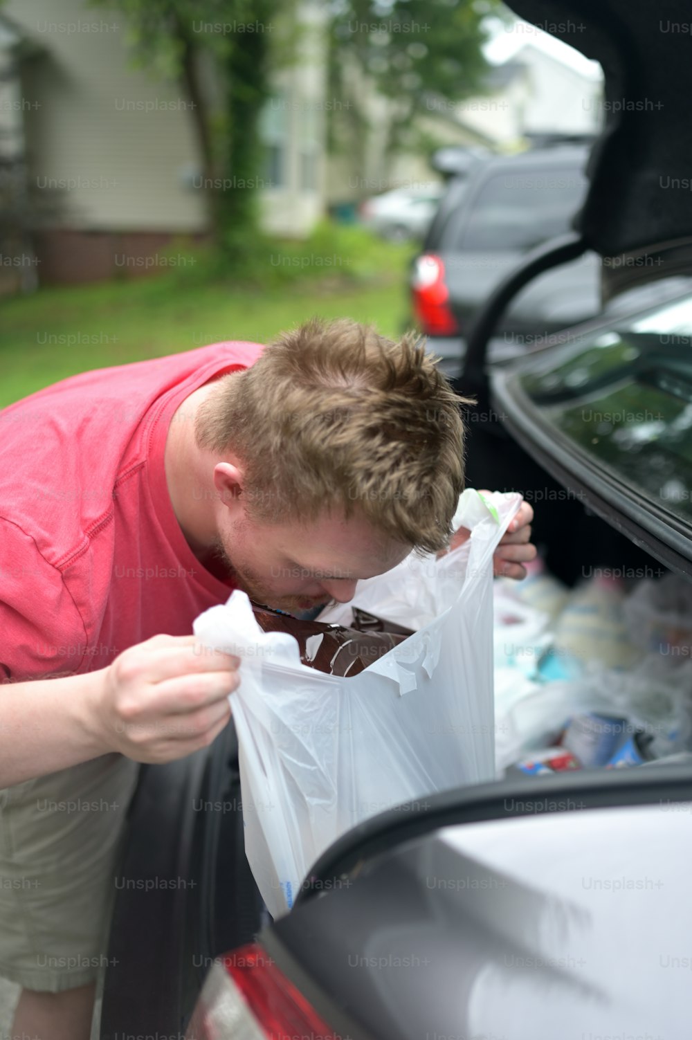 a man opening the back of a car trunk