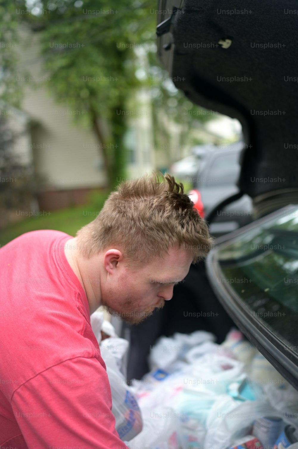 a man with a mohawk standing next to a car