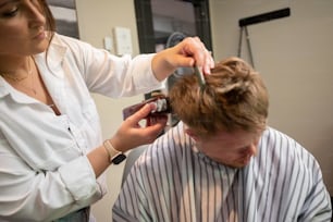 a man getting his hair cut by a woman
