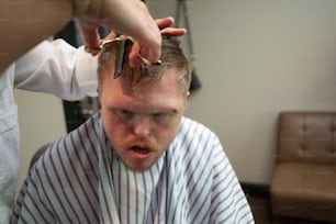 Ein Mann, der sich von einem Friseur die Haare schneiden lässt