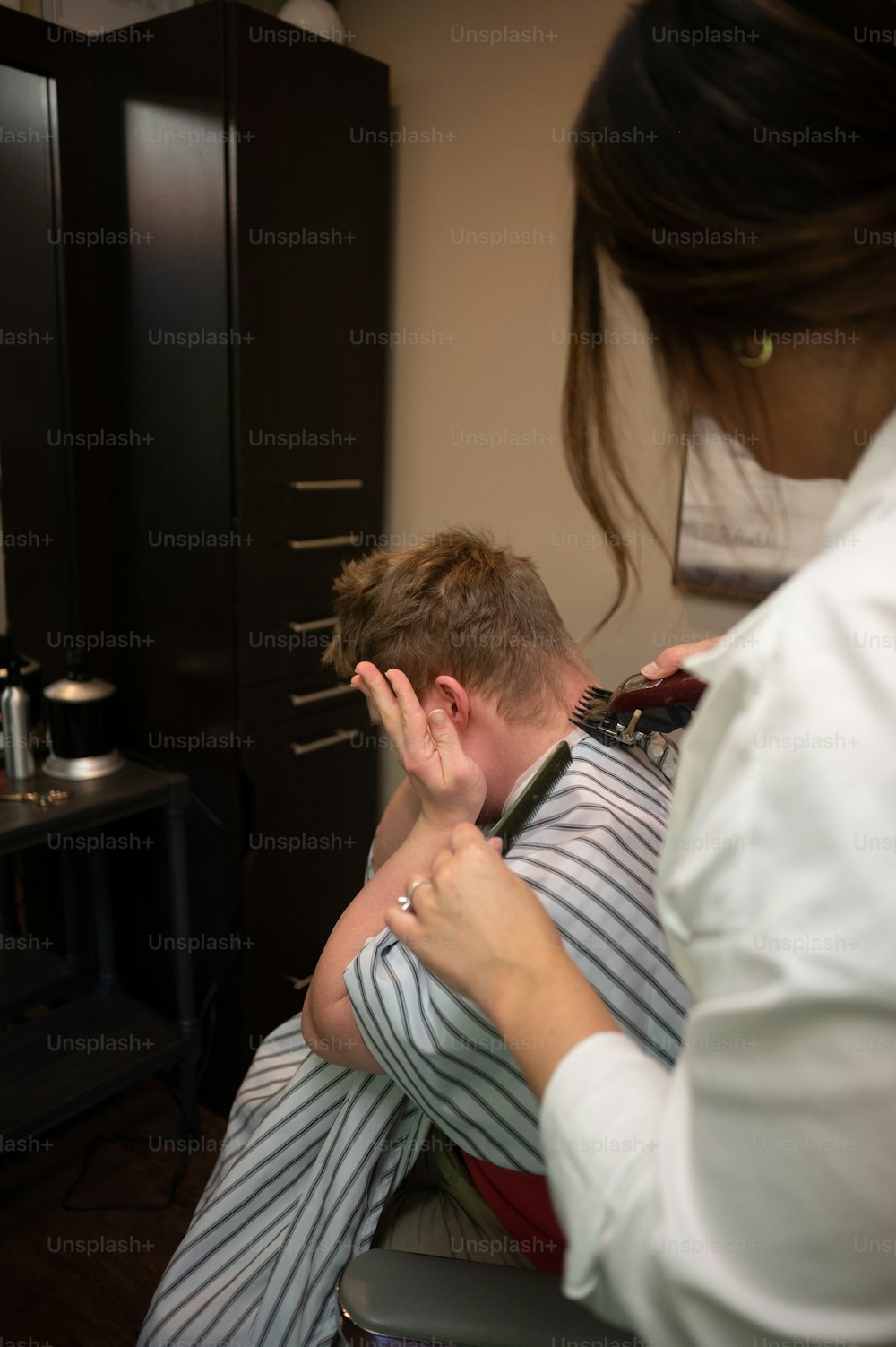 Un homme se fait couper les cheveux par une femme