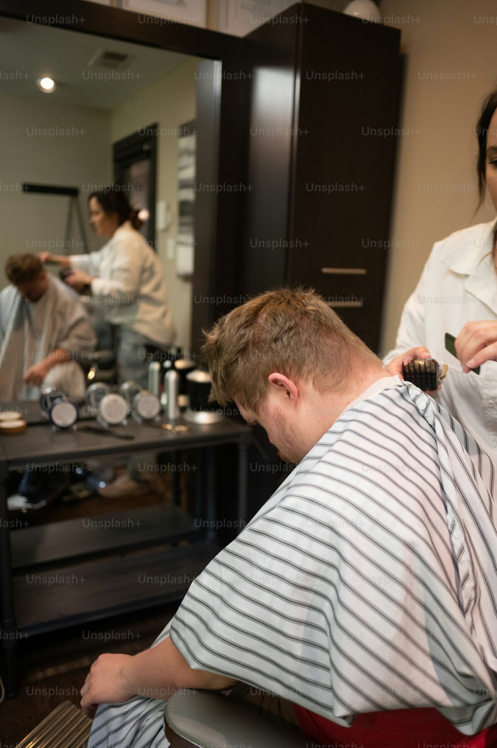 Ein Mann, der sich in einem Friseursalon die Haare schneiden lässt