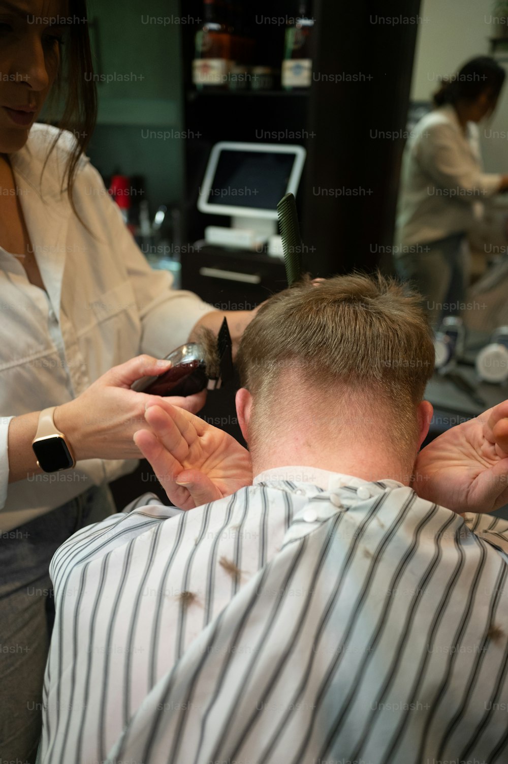 Ein Mann, der sich in einem Friseursalon die Haare schneiden lässt