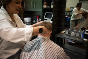 a woman cutting a mans hair in a barber shop