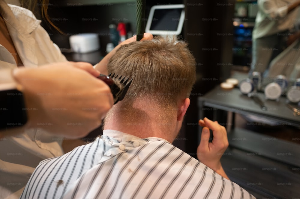 Un hombre cortándose el pelo en una peluquería