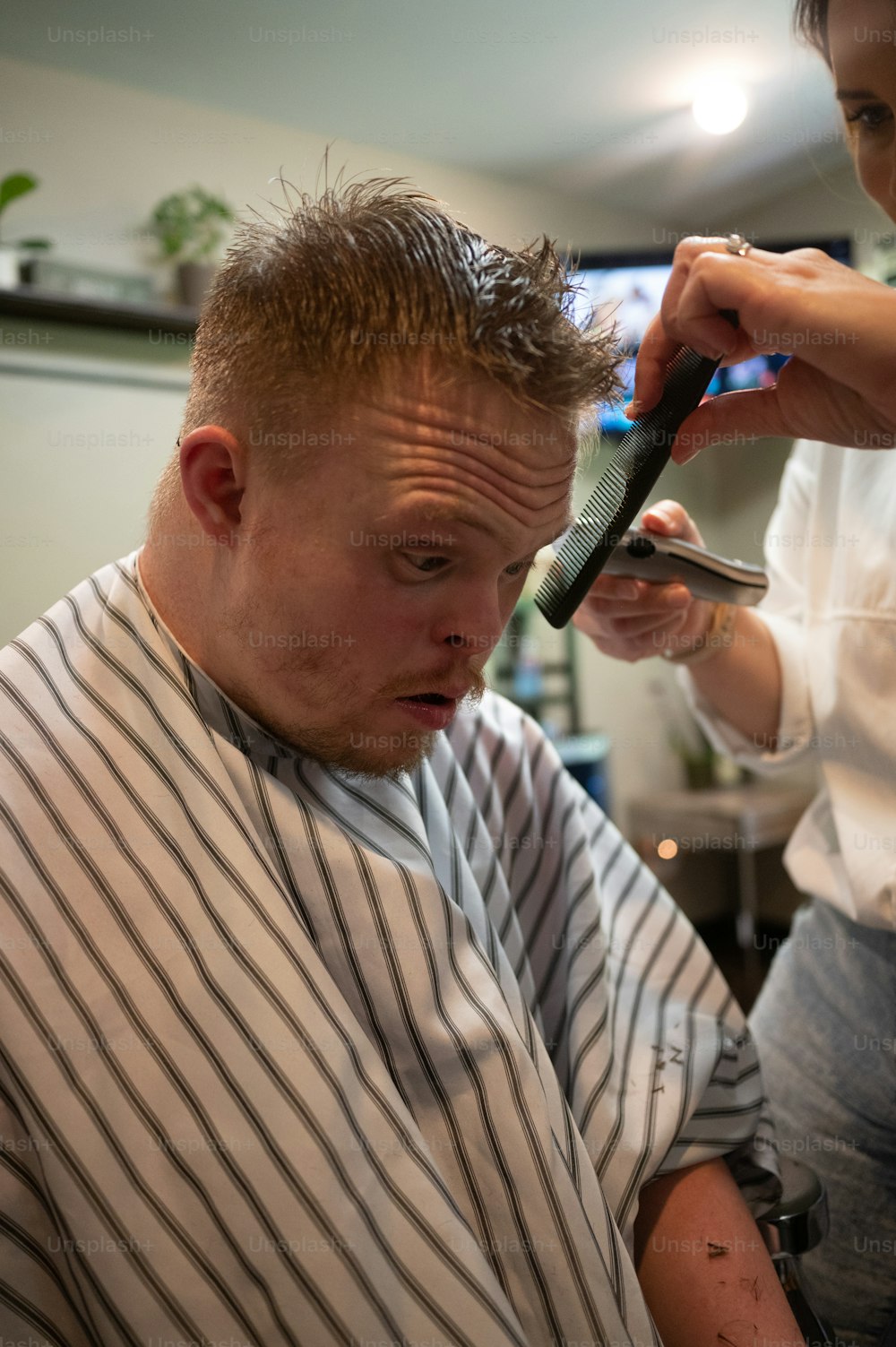 Un hombre cortándose el pelo por un estilista