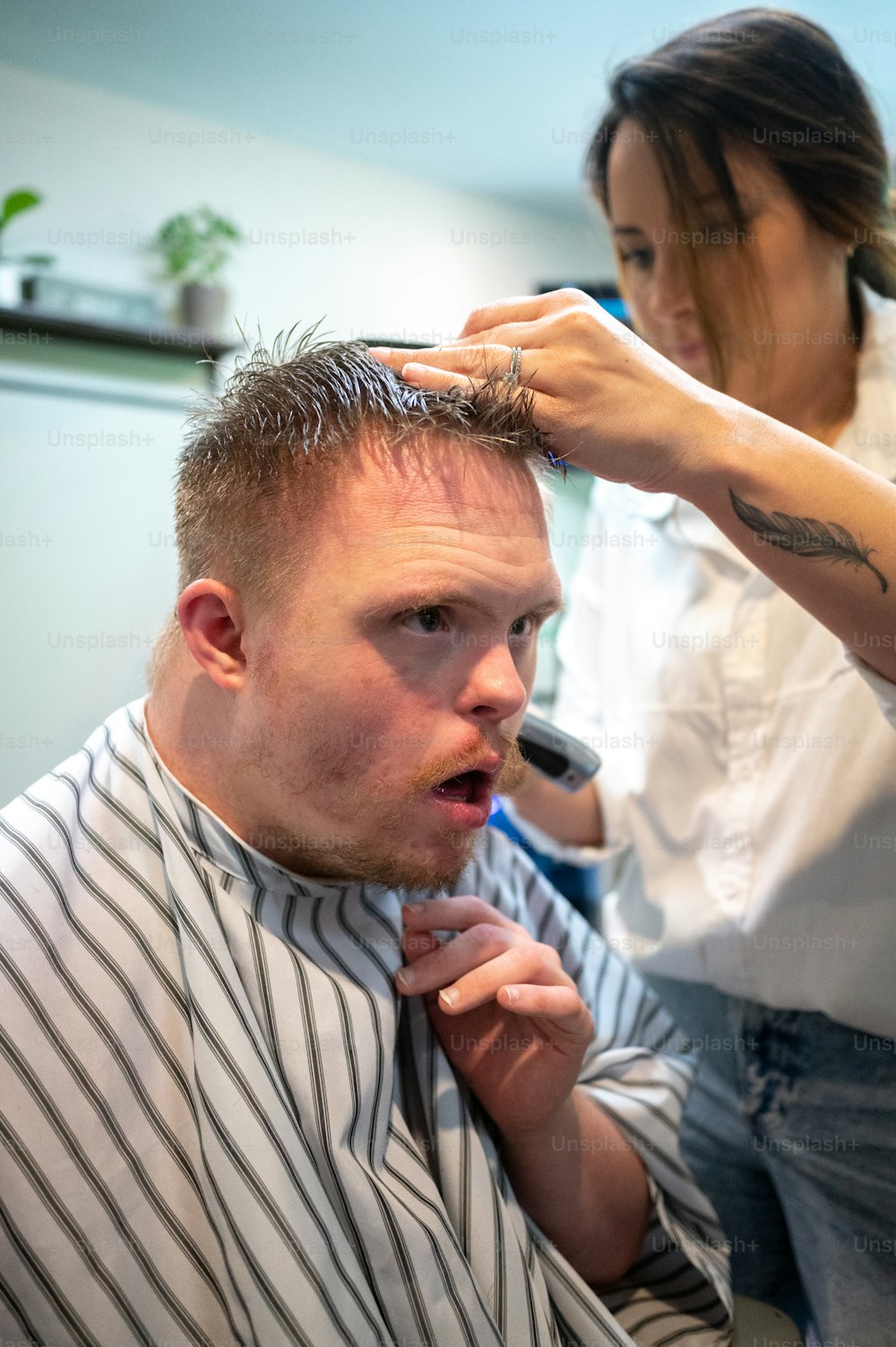Un homme se fait couper les cheveux par une femme