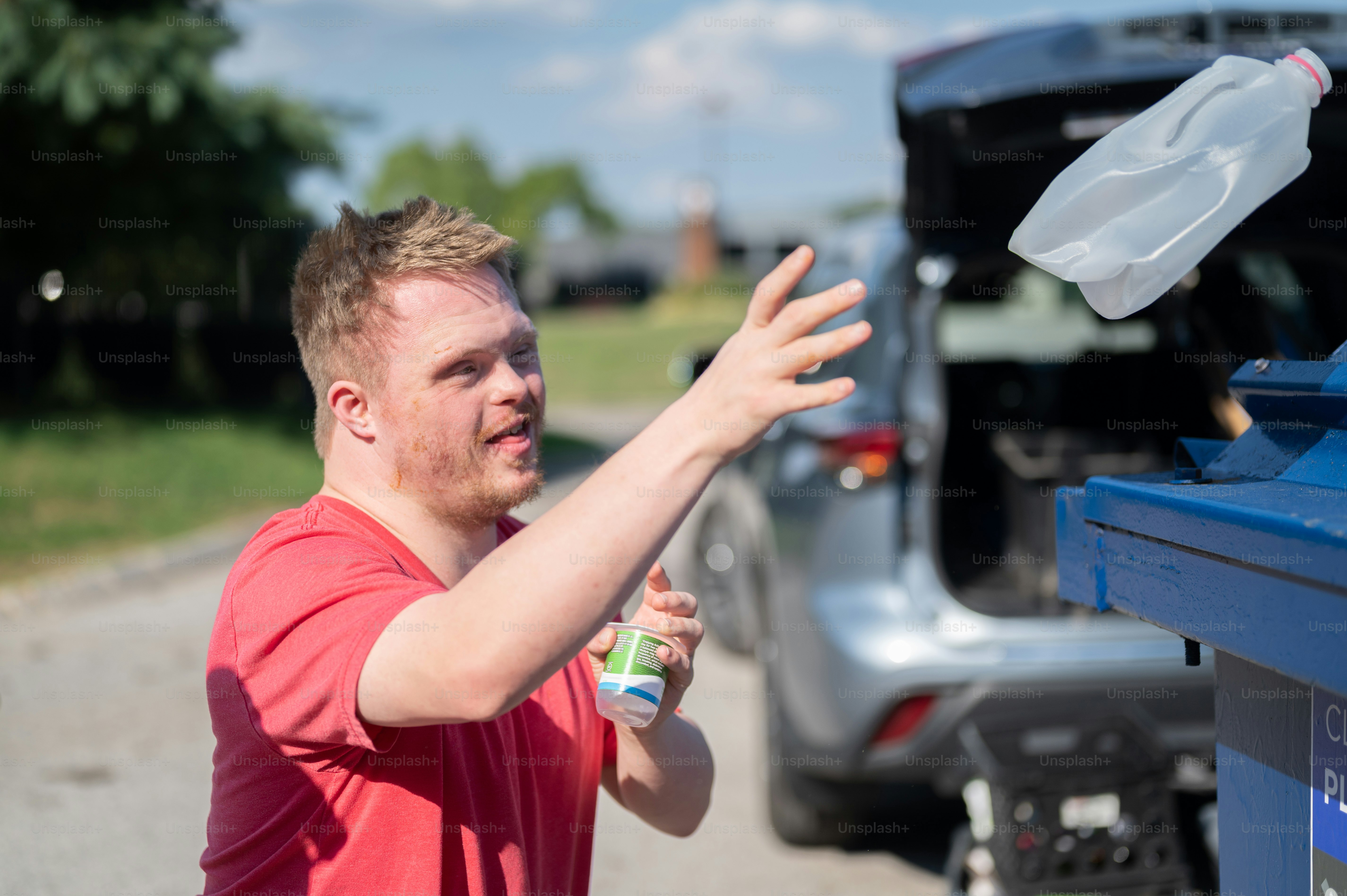 A man throwing a plastic bottle into a trash can photo – Helpful Image ...