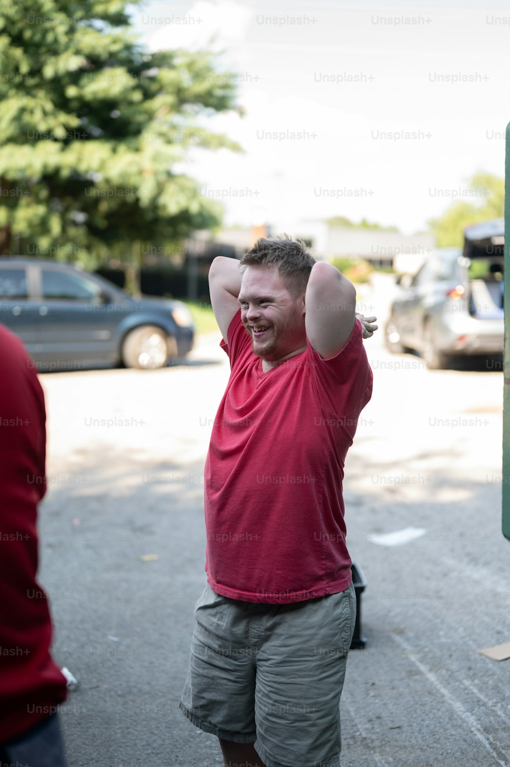 a man in a red shirt is holding his hands up