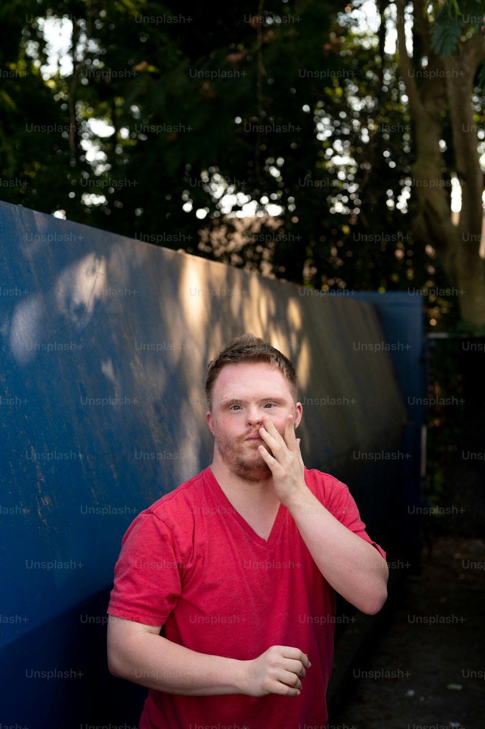 Un homme debout devant un mur bleu