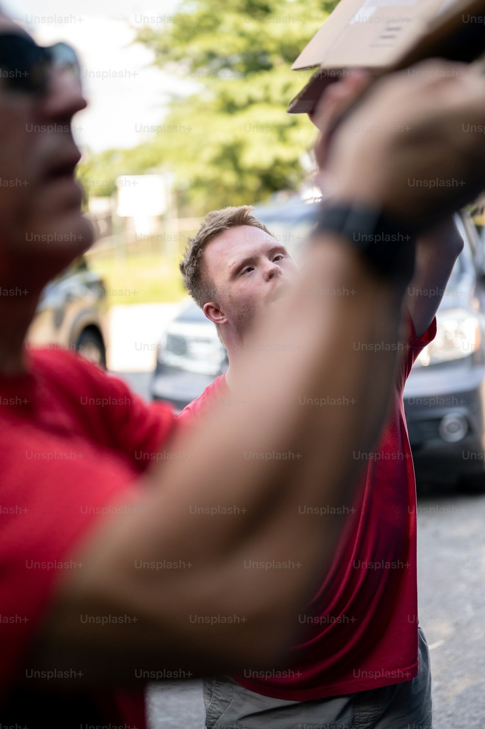 Ein Mann in einem roten Hemd hält eine Kiste in der Hand