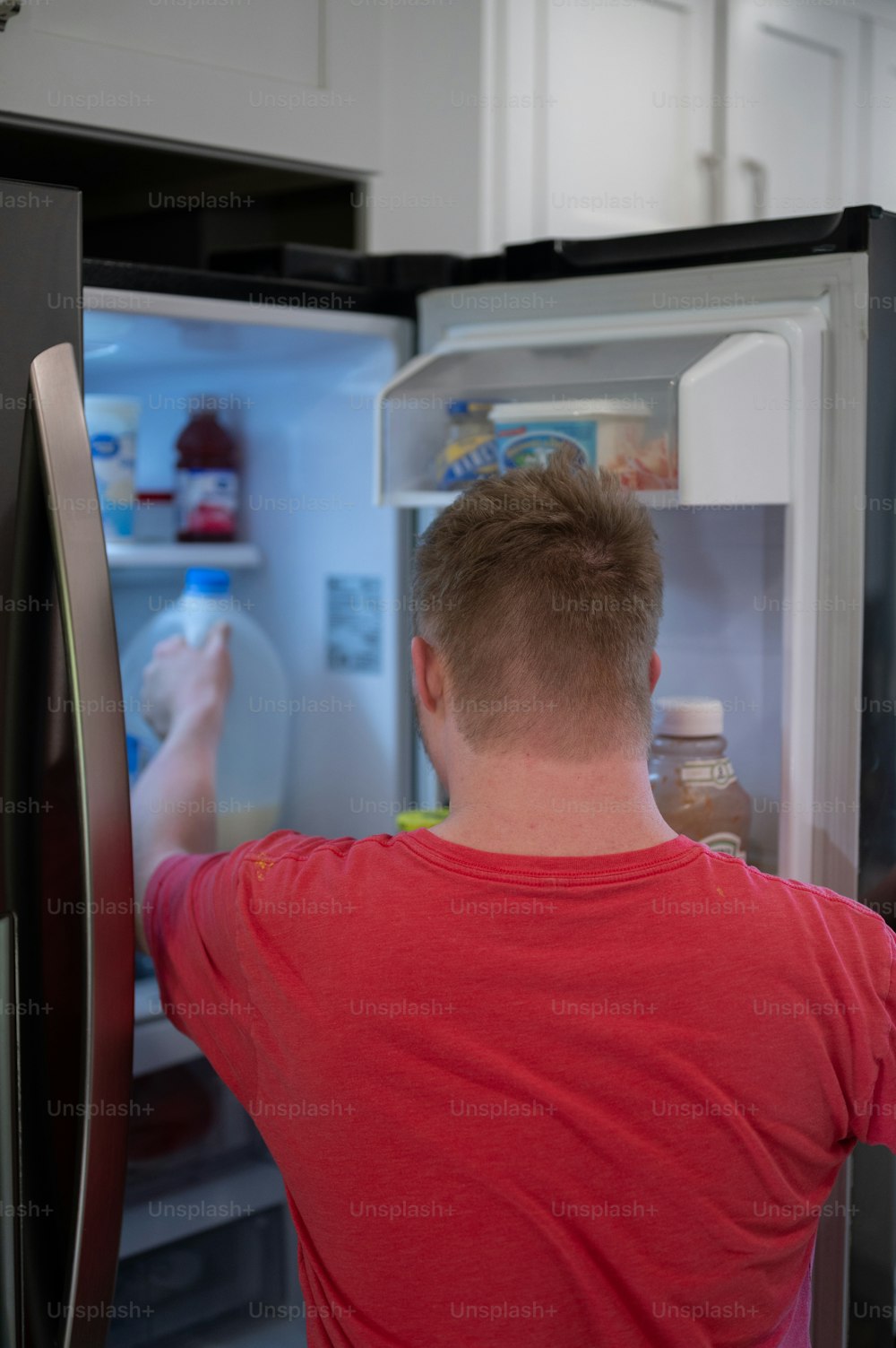 Um homem está olhando dentro de uma geladeira