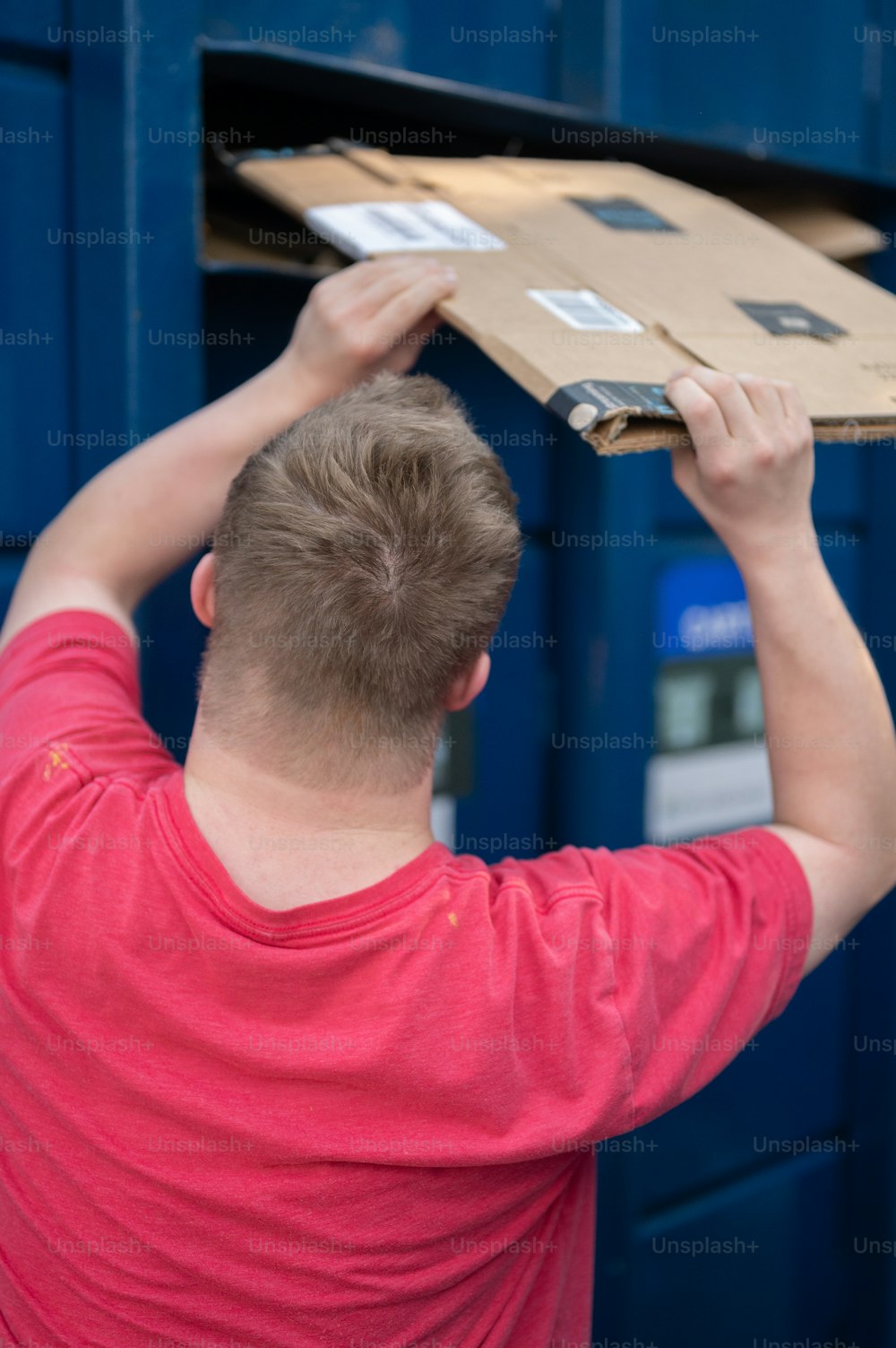 Un hombre poniendo una caja de cartón encima de una caja de cartón