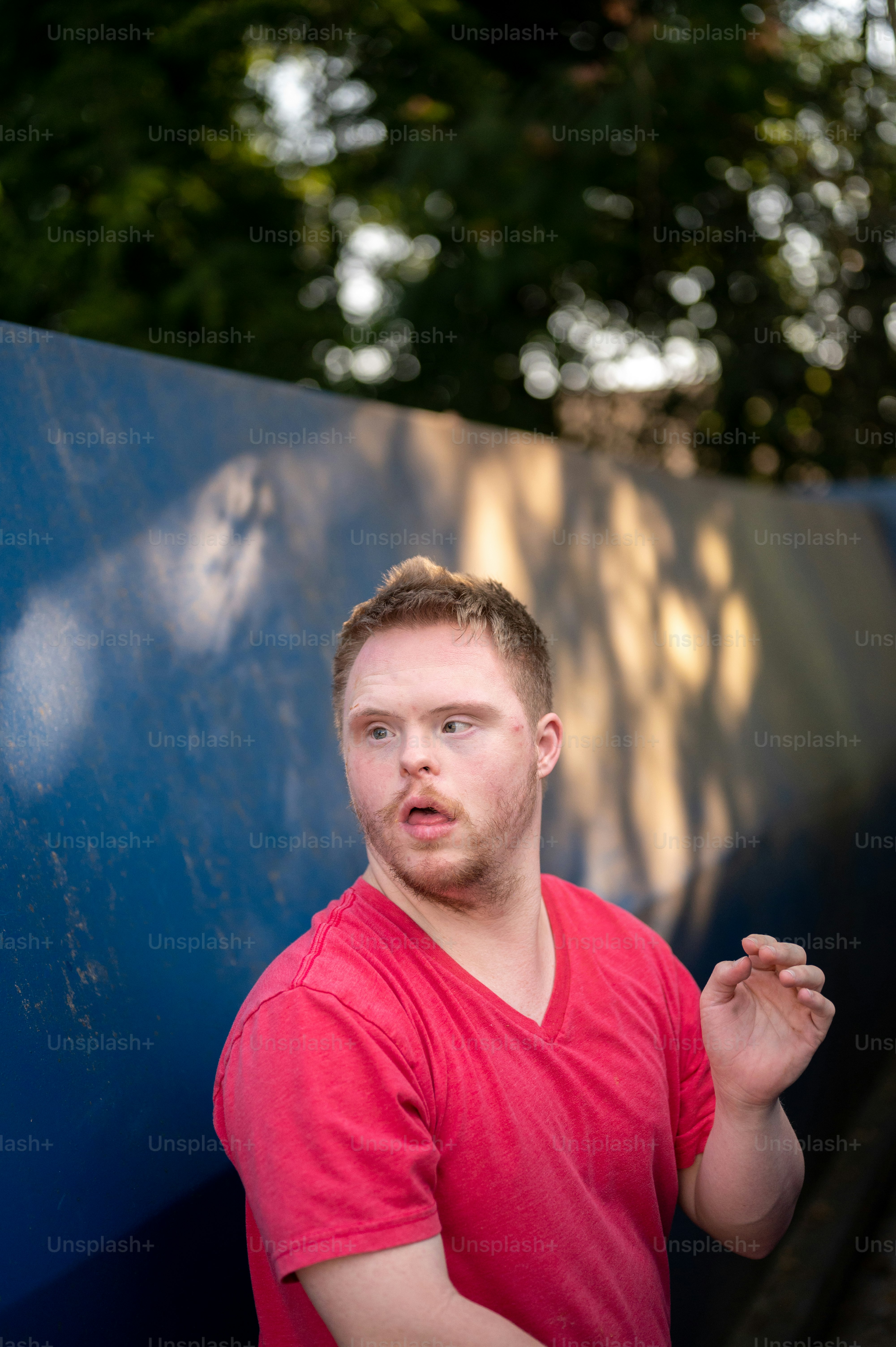 a man standing in front of a blue wall