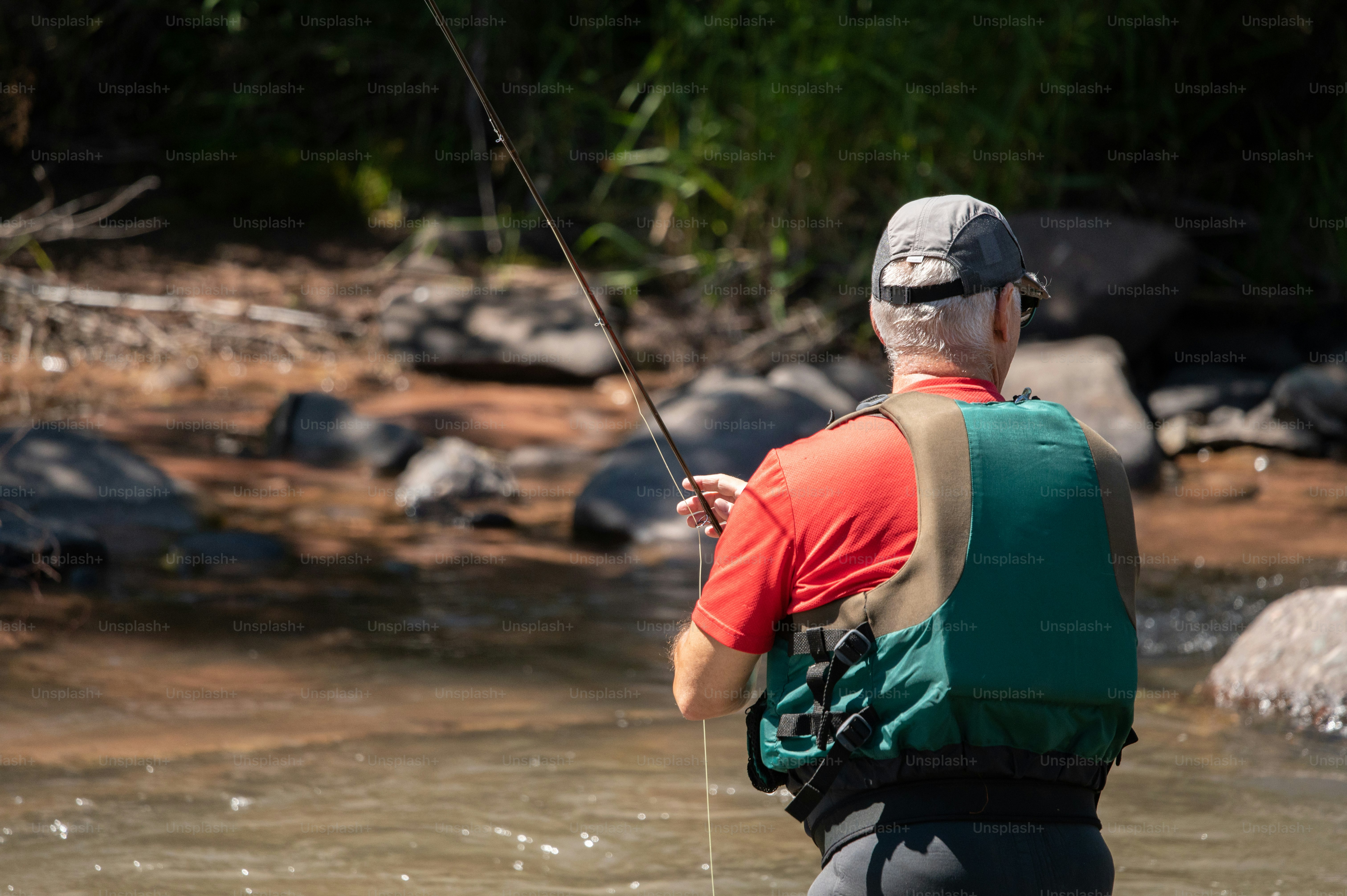 a man standing in a river holding a fishing rod