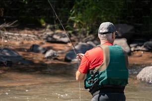 a man standing in a river holding a fishing rod