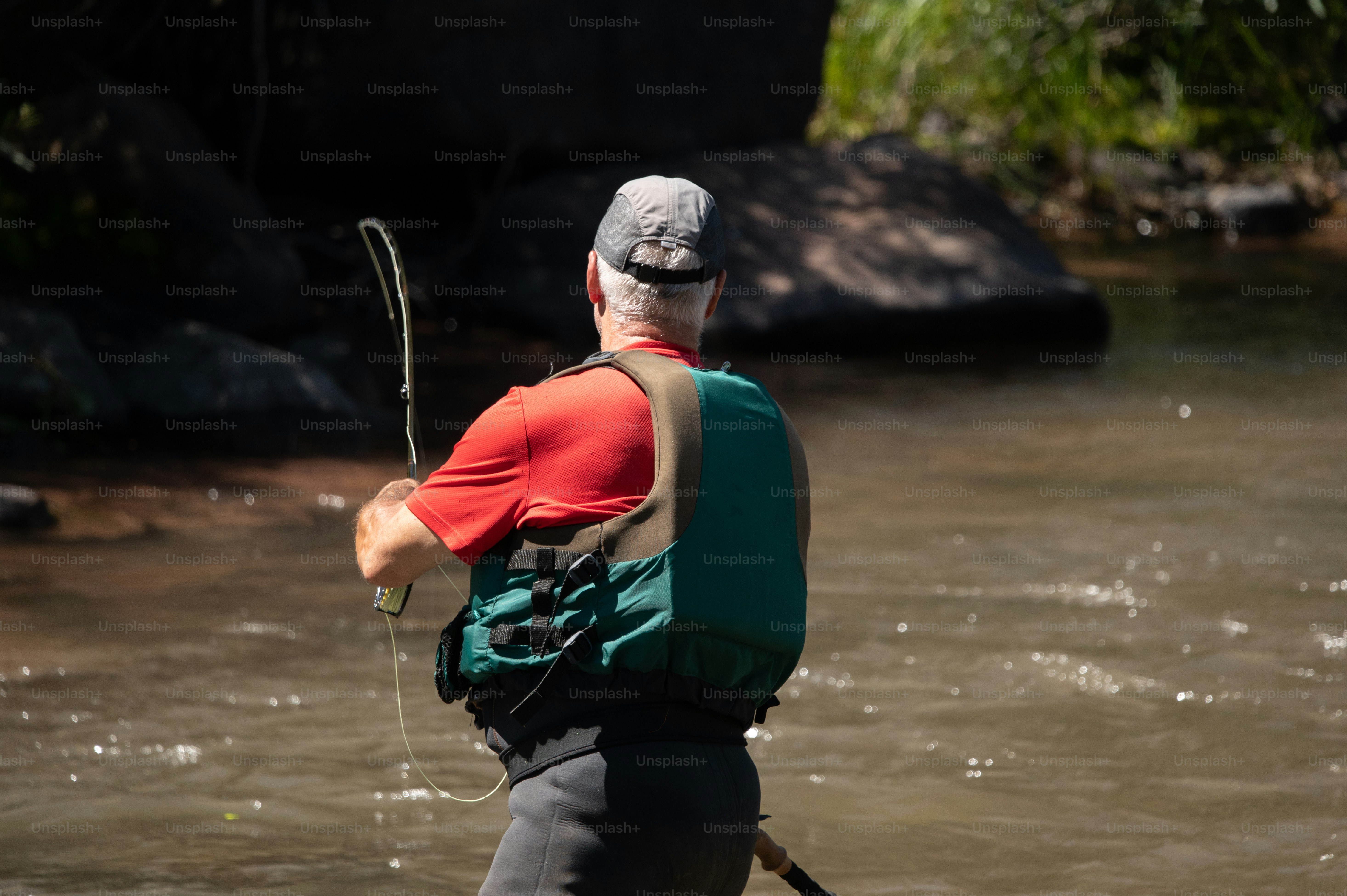 a man standing in a river holding a fishing pole