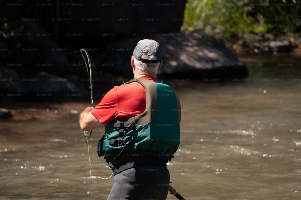 釣り竿を持って川に立っている男