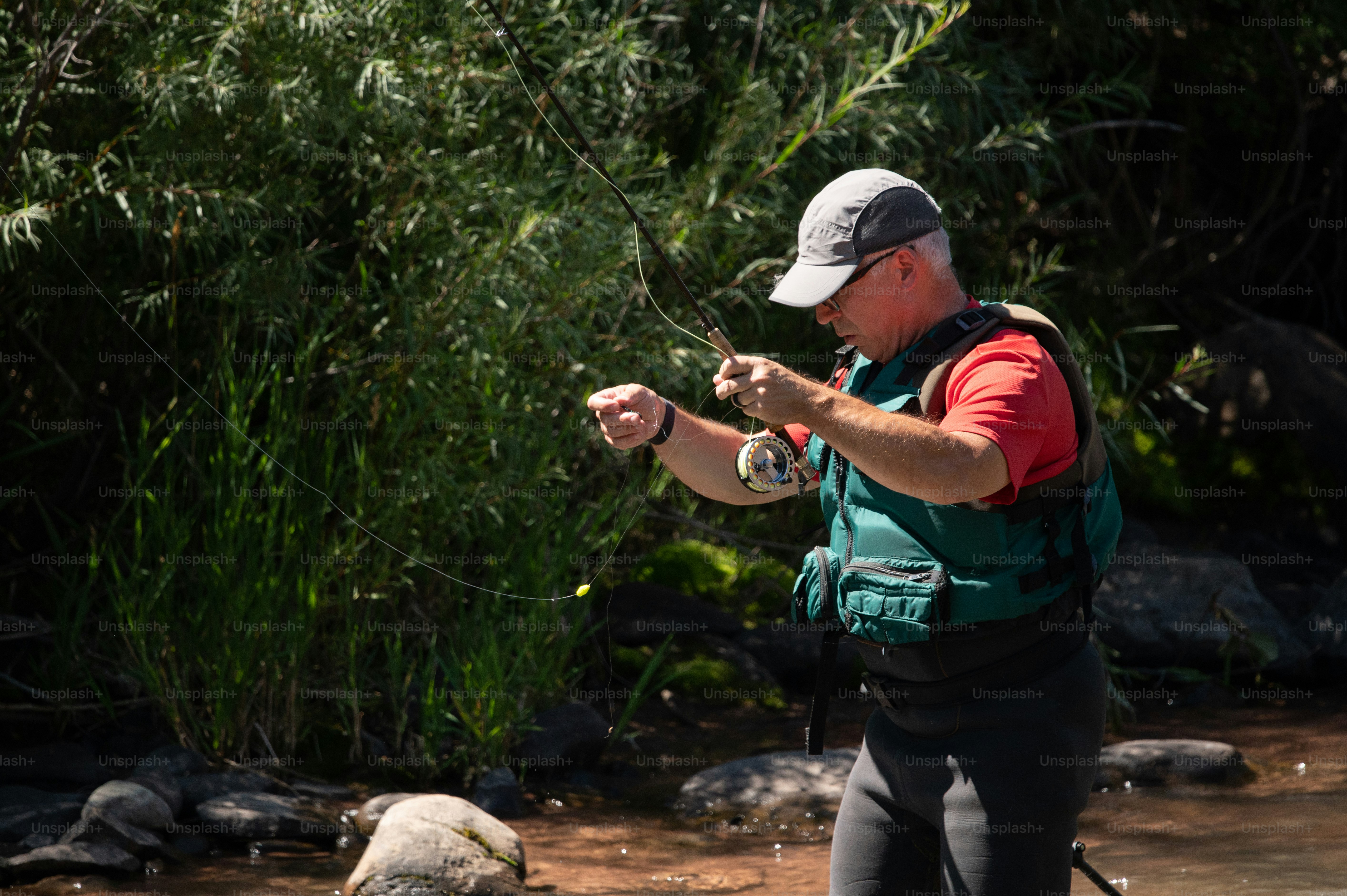 a man standing in a river holding a fish