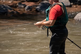a man standing in the water holding a fishing rod