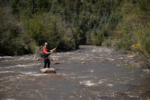 um homem de pé em uma rocha no meio de um rio