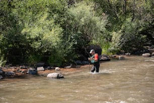 a man standing in a river holding a fishing rod